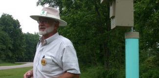 Dick stands next to a nest box at a forest edge